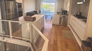 A modern kitchen with a dining area, a built-in oven, and a large window providing natural light. - Room-executive Style Stay, Fast Wi-fi, p (Perth)