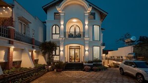 A large, two-story house with a balcony, a driveway, and a parked car. - Yen Stay and Coffee (Xuan Huong - Da Lat)