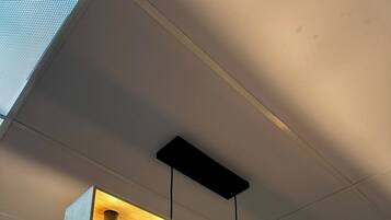Un luminaire moderne à suspendre au plafond, doté de quatre ampoules.
