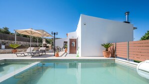 A swimming pool with lounge chairs, a covered seating area, and a building with a door and chimney. - Altura Villa,Private Pool , one storey , for Up to 7 geusts (Saitoures)