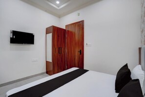 A bedroom with a bed, a wardrobe, a flat-screen TV, and a ceiling light. - Shri Jee Kripa Villas (Mathura)