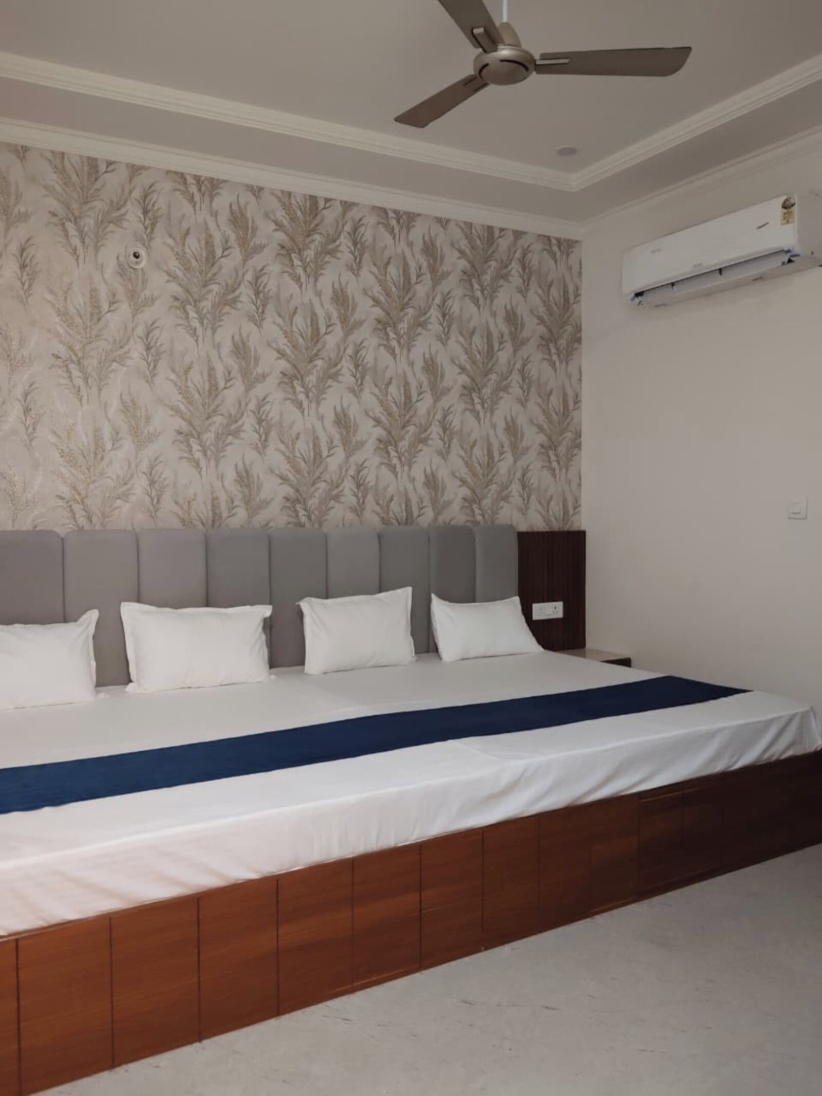 Quarto com uma cama, um ventilador de teto e um ar condicionado.