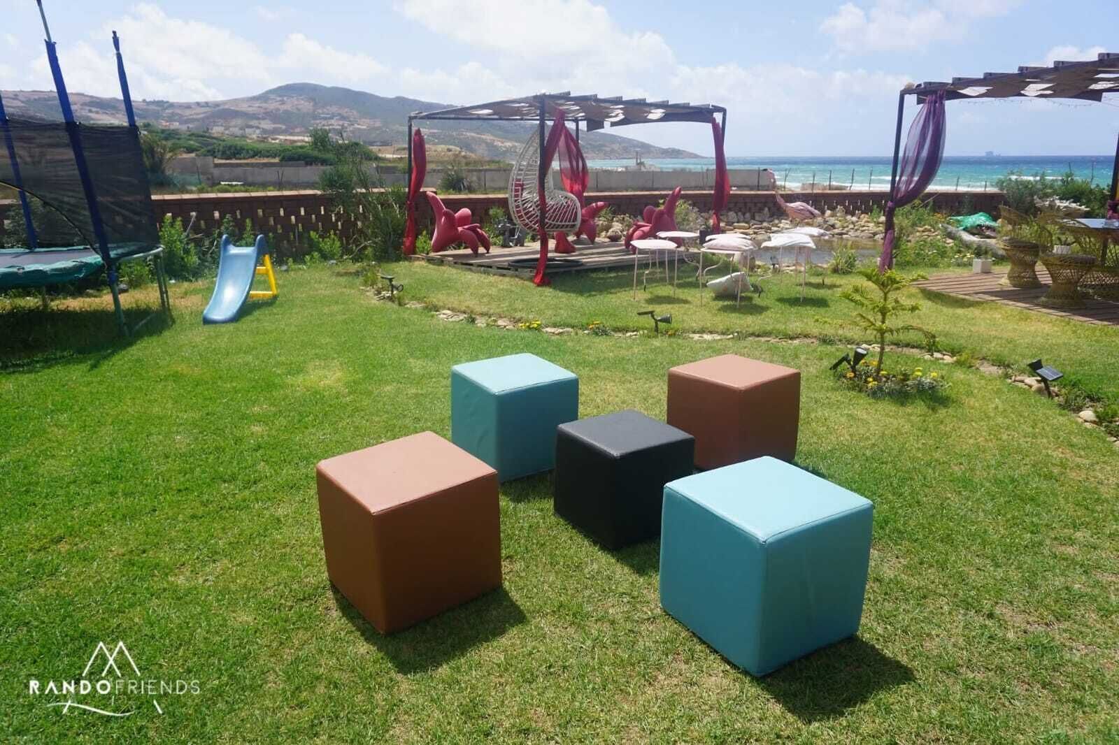Un patio trasero con un tobogán, estructuras de juego coloridas y zonas de estar.