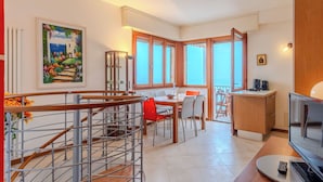 Eine moderne Küche mit Essbereich, einer Treppe mit Geländer und einem Balkon mit Blick.