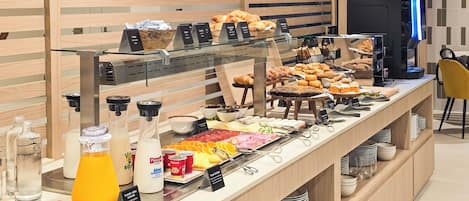 A breakfast buffet with various food items and condiments.
