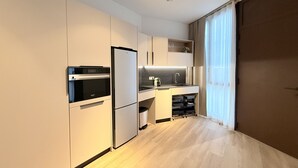 Uma cozinha moderna com eletrodomésticos embutidos, bancada e janela com cortinas.