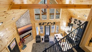 Eine Holzhütte mit Kamin, Sitzgruppe und Esstisch.