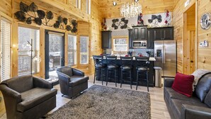 Ein Blockhaus-Interieur mit Küche, Essbereich und Wohnzimmer.