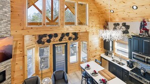 Ein Holzblockhaus-Interieur mit Essbereich, Küche und Kamin.