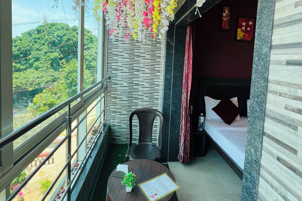 A balcony with a table, chairs, and hanging flowers.