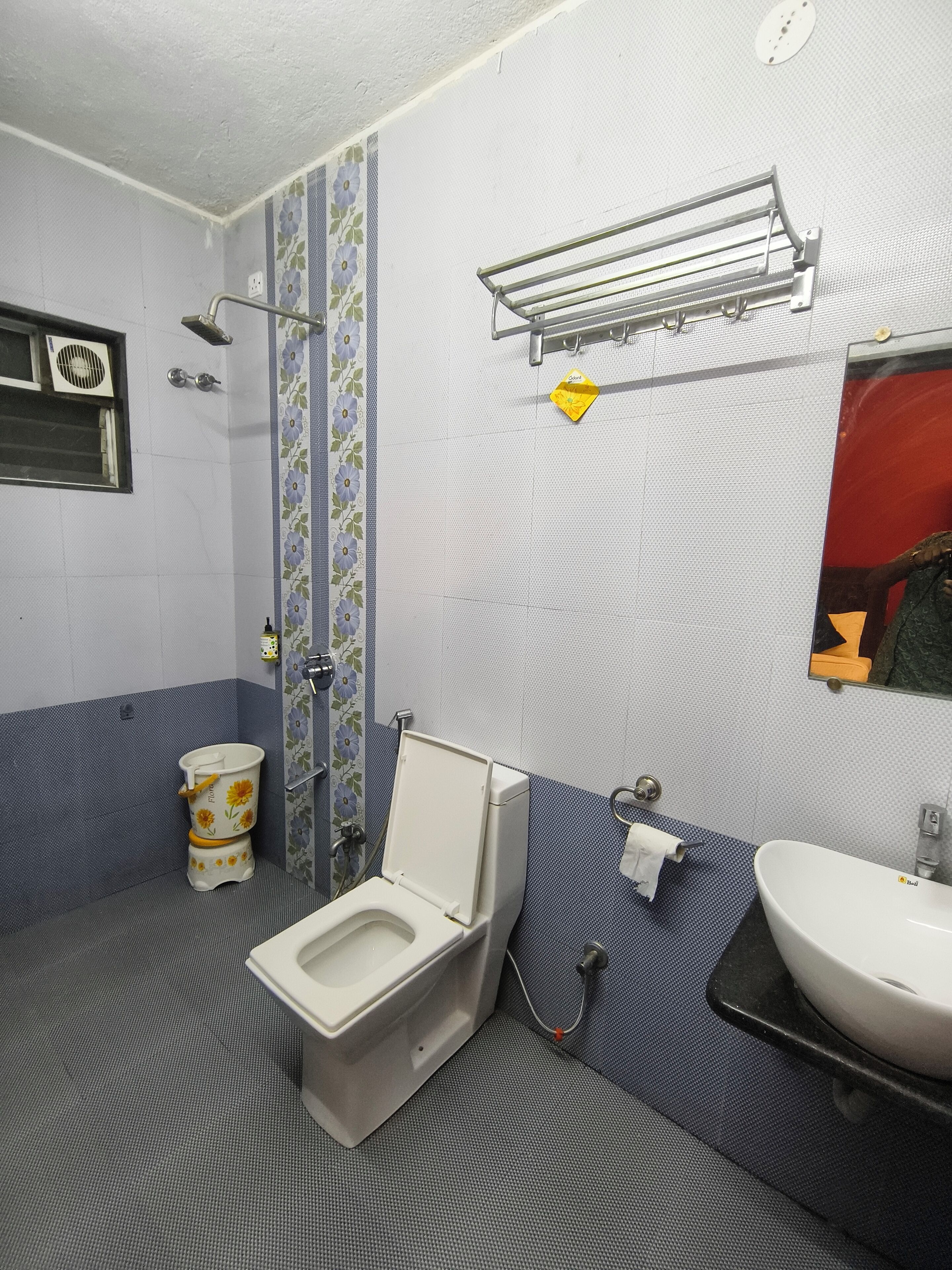 Une salle de bain comprenant des toilettes, un lavabo, une douche et un porte-serviettes.