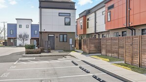 Un moderno edificio residencial con un estacionamiento al frente.