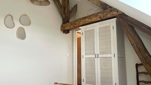 A bedroom with a bed, a wardrobe, a chair, and a hanging light fixture. - La Maison Agoméa (Saint-Georges-sur-Cher)