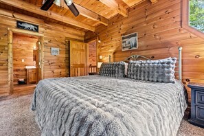 A wooden cabin interior with a bed, a door, and a sign on the wall. - Peaceful 2BR w/Hot Tub*Pool Table*Fireplace*Arcade (Sevierville)