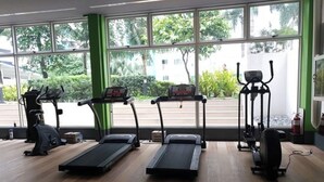Een sportschool met loopbanden, hometrainers en fitnessapparatuur.