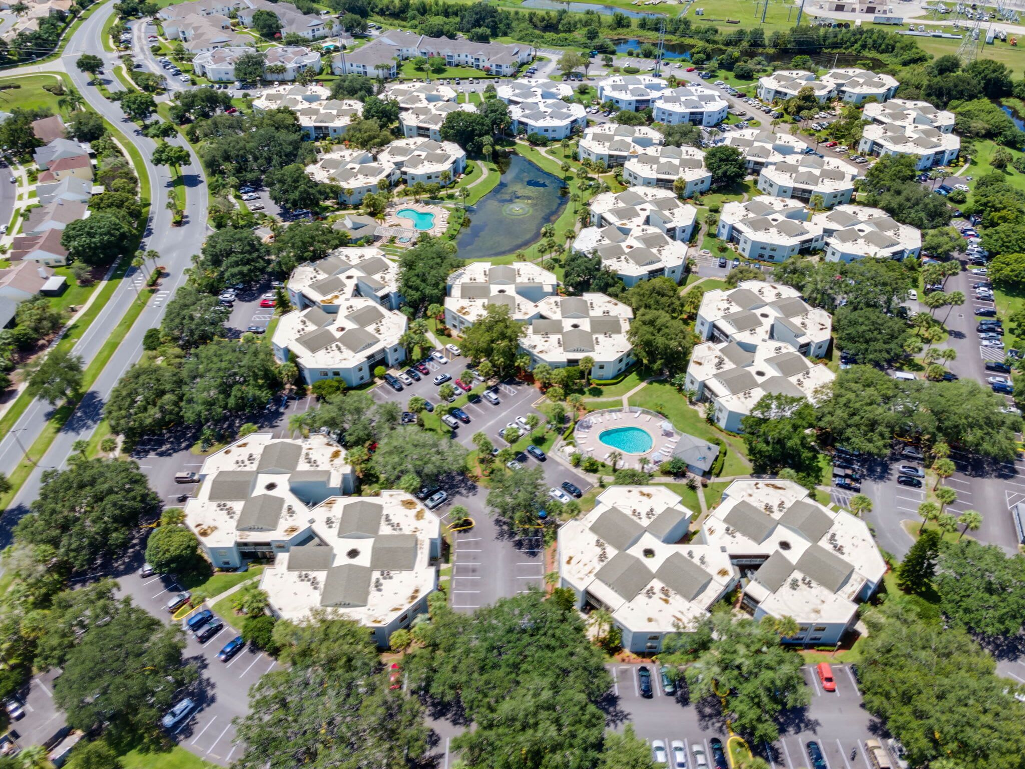 Luchtbeeld van een wooncomplex met meerdere appartementencomplexen, wegen en groene ruimtes.