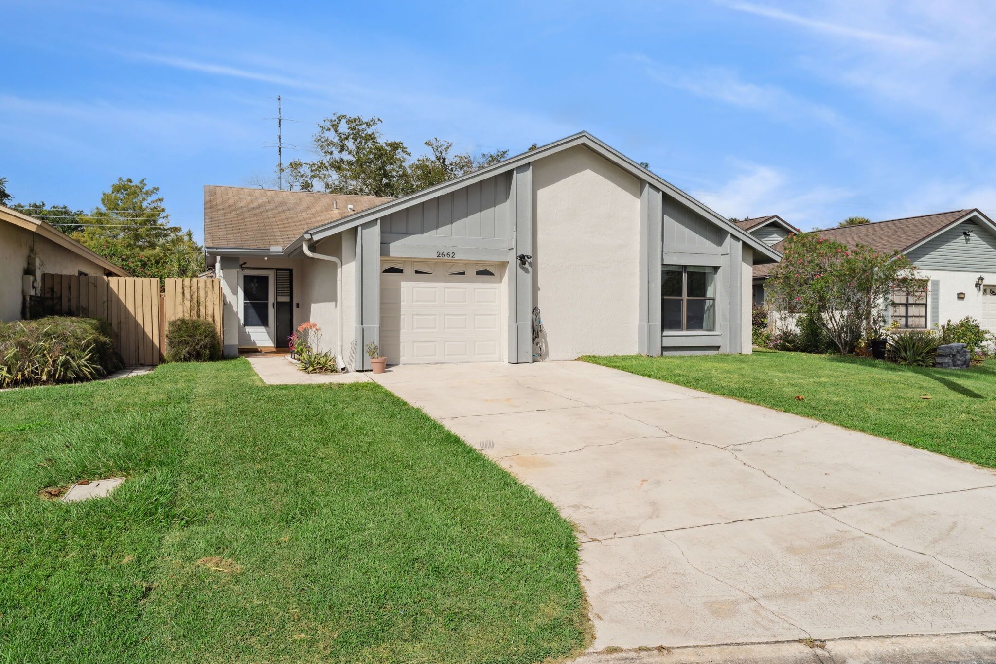 A single-story house with a garage, a front yard, and a driveway.