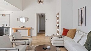 Ein modernes Wohnzimmer mit einer Couch, einem Couchtisch und einem Essbereich mit Tisch und Stühlen.
