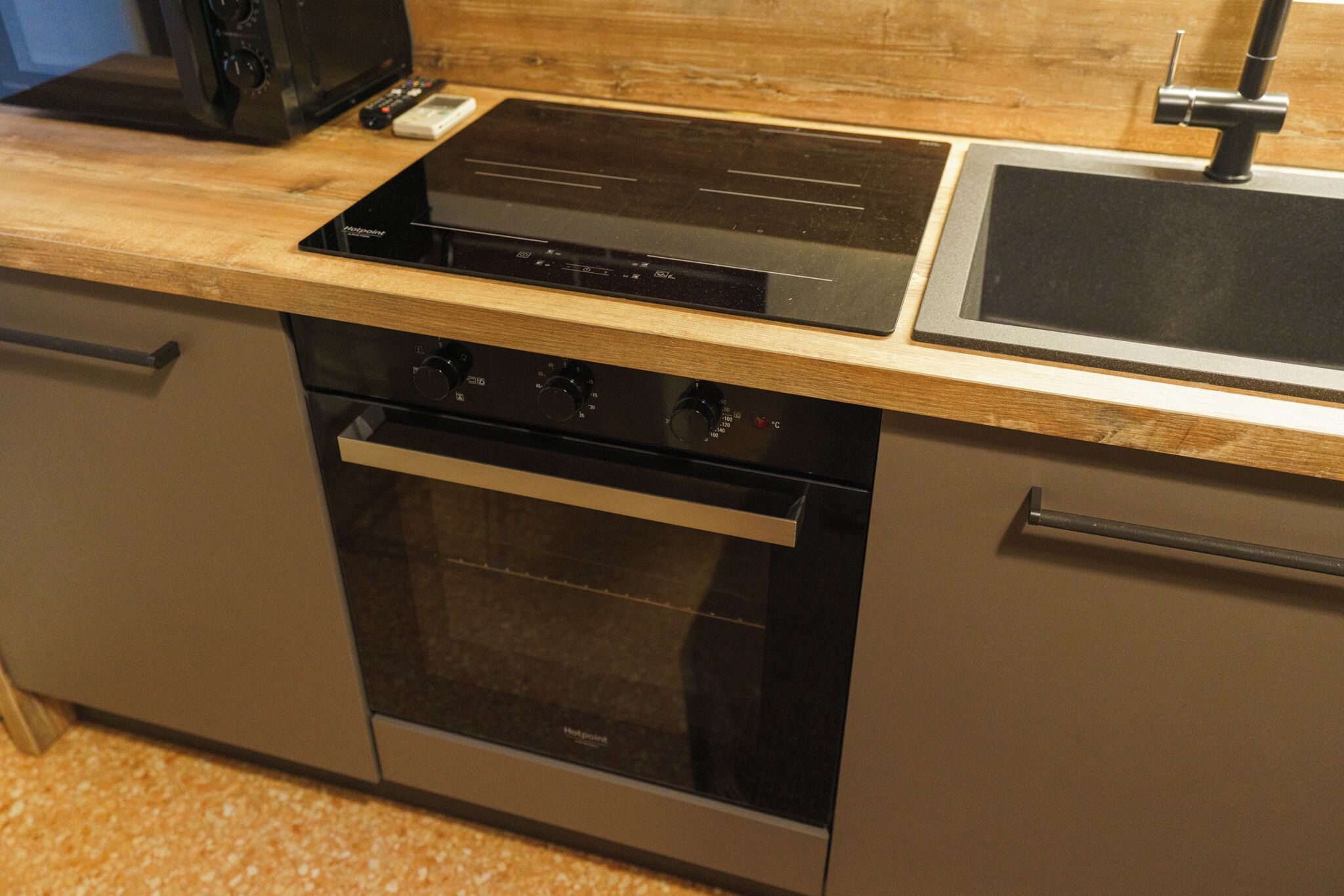 Una cucina con piano cottura integrato, forno e lavello.
