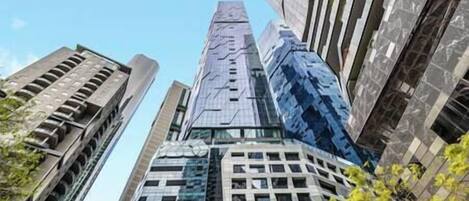 Ein Hochhaus mit modernem architektonischen Design, das Glas- und Betonelemente kombiniert.