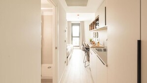 A narrow, well-lit hallway leading to a bedroom with a large window. - Canvas Pamplona Plazaola  (Pamplona)