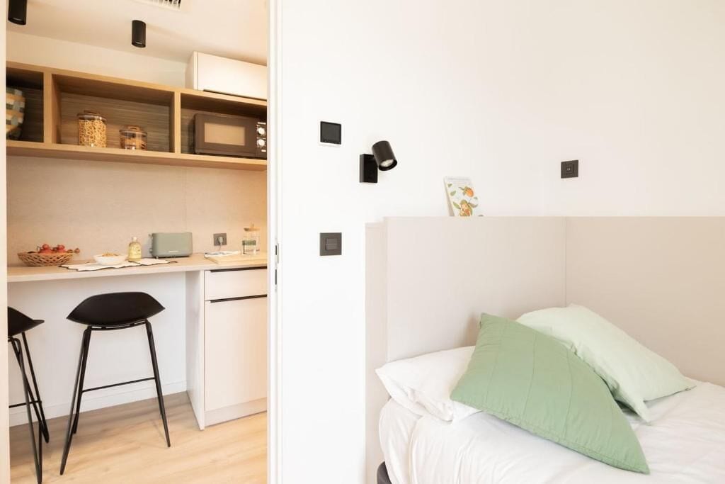 A modern room with a bed, a desk, and a chair.