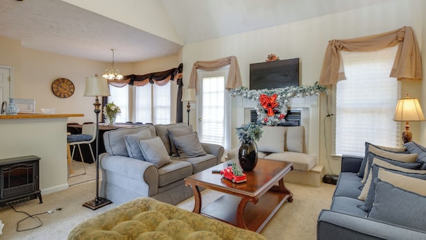 A living room with a sofa, a coffee table, a fireplace, and a clock on the wall. - Great for Families! Suburban Home in Ruther Glen (Ruther Glen)