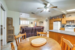 A spacious kitchen with wooden cabinets, a central island, and a ceiling fan.