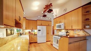 A kitchen with wooden cabinets, a granite countertop, a refrigerator, a microwave, and a stove. - On 10 Acres! Serene Nevada City Retreat w/ Hot Tub (Nevada City)