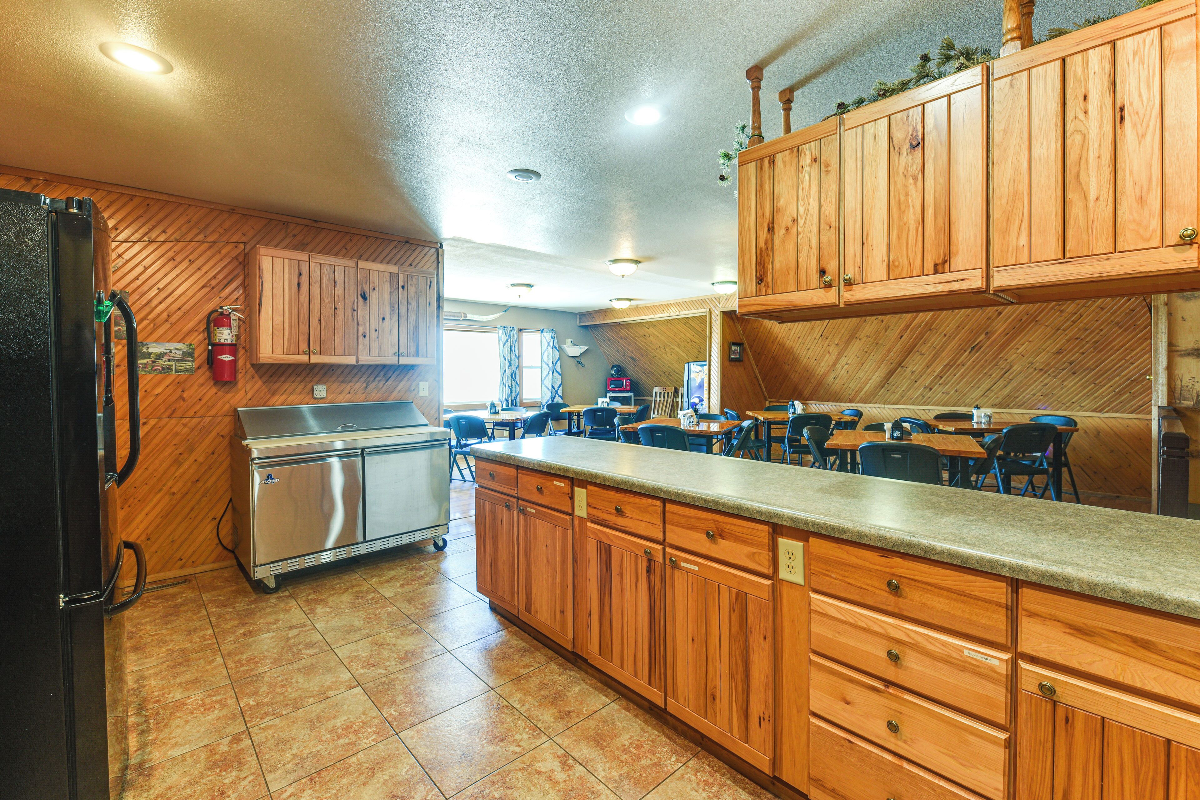 A kitchen with wooden cabinets, a stainless steel refrigerator, and a countertop.