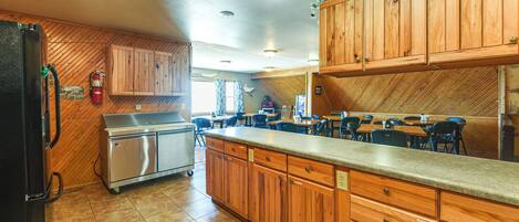 A kitchen with wooden cabinets, a stainless steel refrigerator, and a countertop.