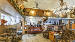A rustic interior with wooden walls, a leather sofa, and antler decorations. - Hot Tub, Fire Pit! Massive Mt Vernon Hunting Lodge (Mount Vernon)