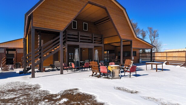 A large wooden building with a sloped roof, outdoor seating area with chairs and tables, and a staircase leading to an upper level. - Hot Tub, Fire Pit! Massive Mt Vernon Hunting Lodge (Mount Vernon)