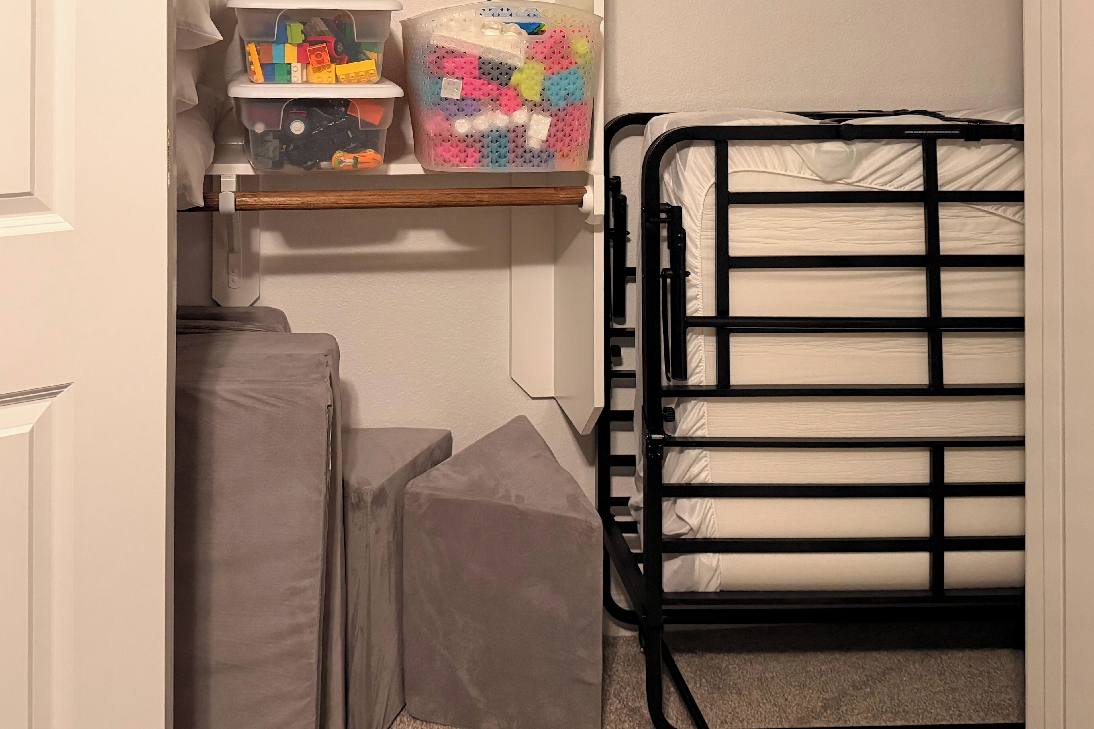 A bunk bed with a mattress and a storage shelf above it.