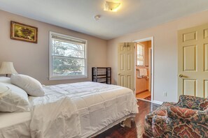 A bedroom with a bed, a chair, a window, and a door leading to a bathroom. - 5 Mi to Broadway Fun! Group-ready Nashville Home (Nashville)
