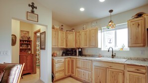A kitchen with wooden cabinets, a microwave, a sink, and a window with a view. - Horse Ranch Hideaway! Wickenburg Equestrian Casita (Wickenburg)