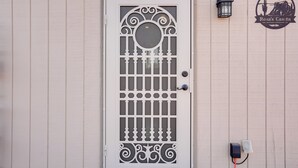 A white door with decorative metal grilles and a circular window. - Horse Ranch Hideaway! Wickenburg Equestrian Casita (Wickenburg)