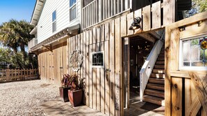 A wooden building with a welcoming sign, a staircase, and a door leading inside. - Elevated Pet-Friendly Retreat Near the Beach (Tybee Island)