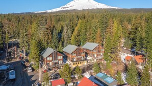 A lodge with multiple buildings, a road, and a forested area with a mountain in the background. - Après & Adventure: Mt Hood Retreat in Gov Camp! (Government Camp)