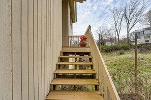 A wooden staircase leading to a building's entrance, with a flower pot on the top step.