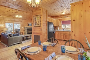 Ein Holzblockhaus-Innenraum mit Essbereich, Küche und Wohnzimmer.