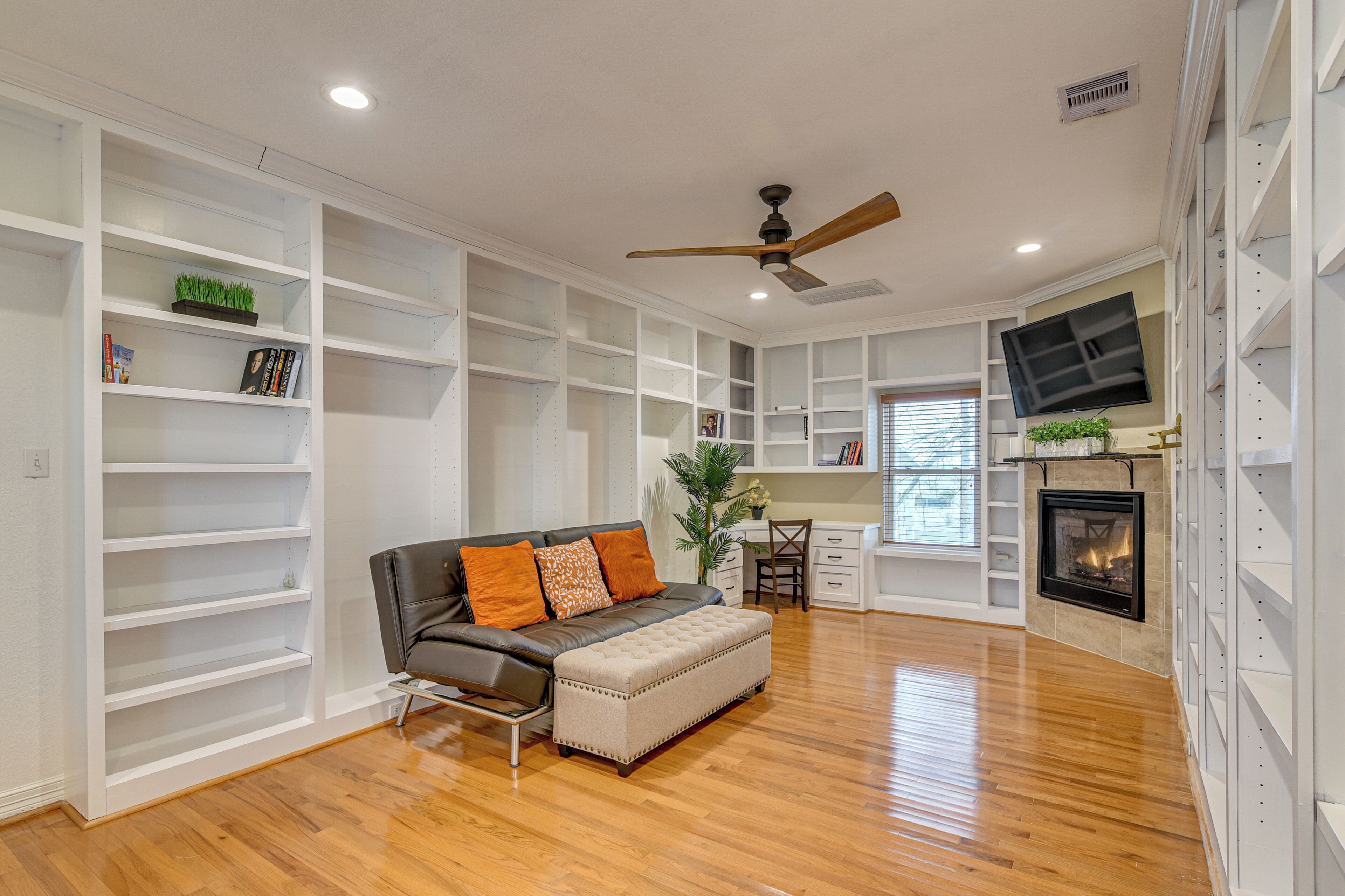 A living room with a fireplace, a sofa, and built-in shelves.