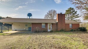 A single-story brick house with a covered porch and a water tank in the background. - 2 Mi to MSU Campus! Family Abode w/ Spacious Yard (Starkville)