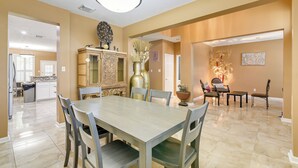 A spacious dining area with a large table and chairs, a decorative cabinet, and a chandelier. - 3,500-sq-ft Retreat w/ Private Yard in Sugar Land! (Sugar Land)