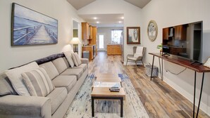 A spacious living area with a sofa, coffee table, and a painting of a pier. - Dog-friendly Home: Near Hot Springs Natl Park! (Hot Springs)