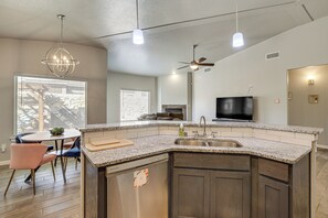 A modern kitchen with granite countertops, a built-in dishwasher, a large island, and a ceiling fan. - Near Parks & Venues: Upper Valley Family Home! (El Paso)