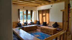 A cozy room with a wooden bench, a table, and a view of the outdoors. - Semba Retreat (Hunder)