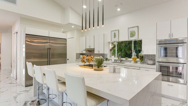 A modern kitchen with a large island, stainless steel appliances, and white cabinetry. - 8,100-sq-ft Parkland Estate w/ Luxe Outdoor Oasis! (Parkland)