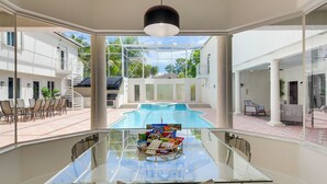 A glass table with snacks, a pool, and a view of a white building with a staircase. - 8,100-sq-ft Parkland Estate w/ Luxe Outdoor Oasis! (Parkland)