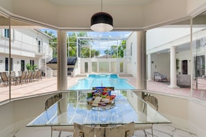 A glass table with snacks, a pool, and a view of a white building with a staircase. - 8,100-sq-ft Parkland Estate w/ Luxe Outdoor Oasis! (Parkland)